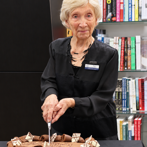 Patron Beckie Rout cutting the cake